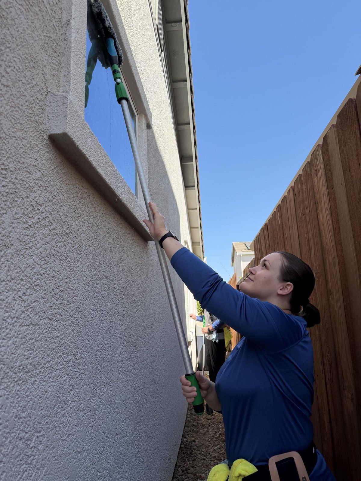 Cleaning a high window with a water fed pole in the Anatolia neighborhood of Rancho Cordova, CA