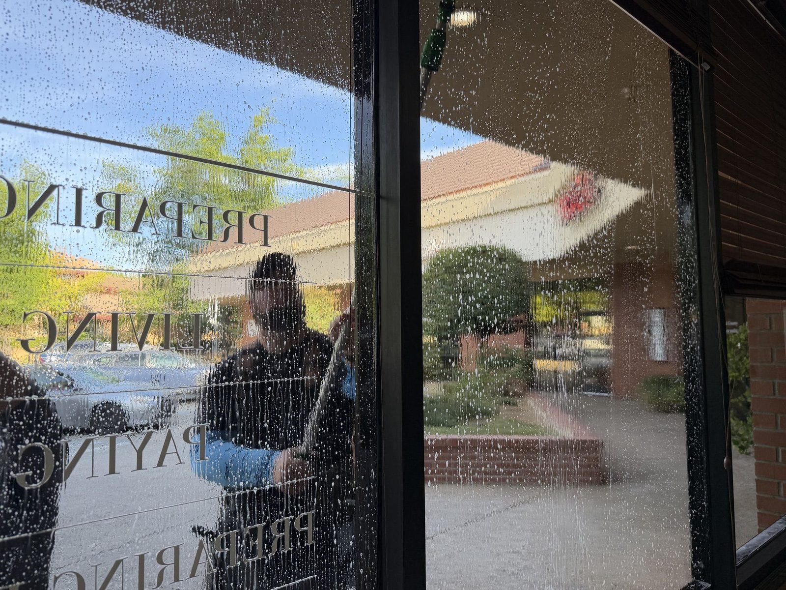 Office glass being cleaned, seen from inside the suite, in Auburn, CA