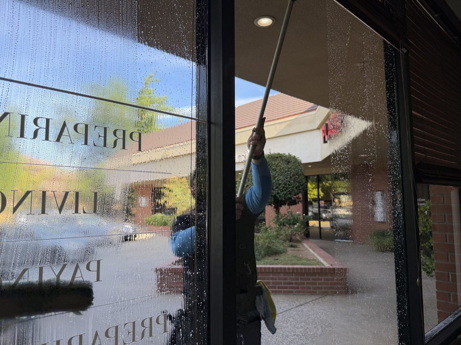 Cleaning upper storefront glass with a water fed pole in Auburn, CA