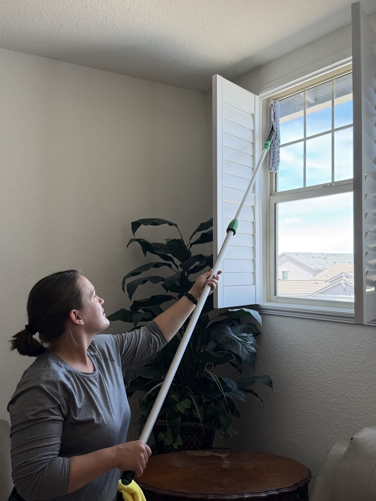 Cleaning tall interior glass with an extension pole at a home in Anatolia, Rancho Cordova, CA