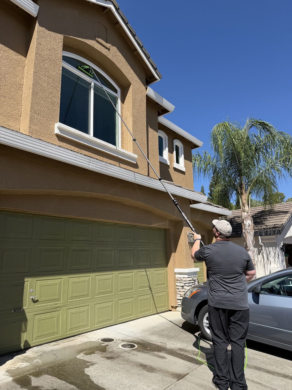 Cleaning second story windows at a home in Roseville, CA with a water fed pole